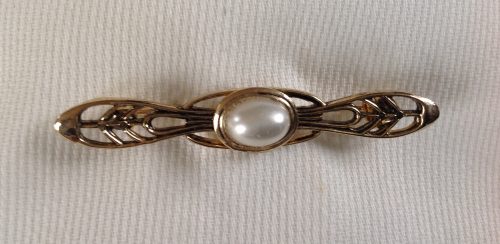 Vintage goldtone with an oval faux pearl and filigree stock pin